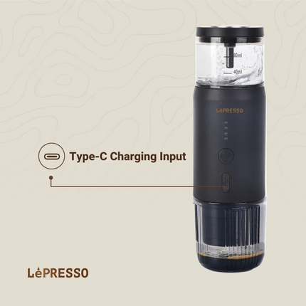 Black LéPRESSO coffee maker with Type-C charging input on a beige background