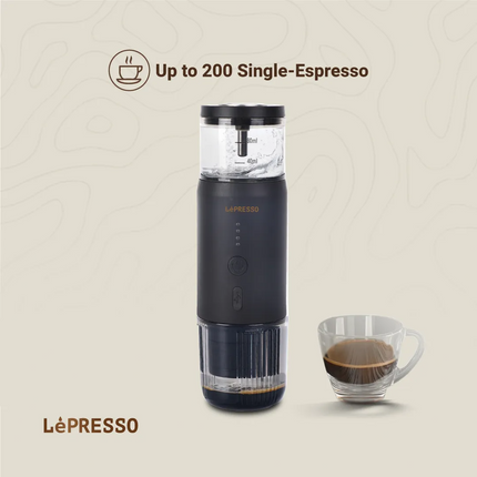 Black LéPresso coffee maker with a cup of espresso on a beige background