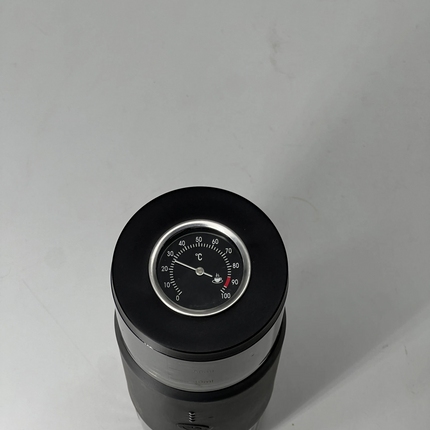 Black and silver cylindrical device with a gauge on a white background