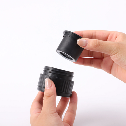 Two black camera lens elements held by a hand against a white background