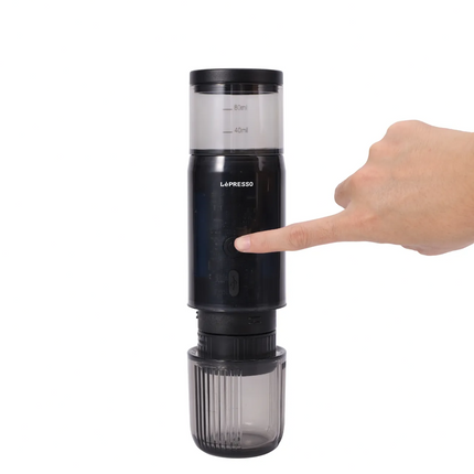 Hand holding a black LaPrezzo coffee grinder on a white background