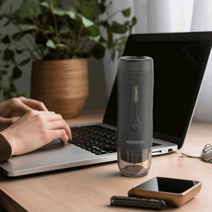 Gray travel mug on a desk with a laptop and phone