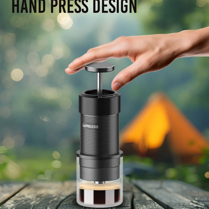 LéPresso hand press coffee maker on a wooden surface with a blurred natural background