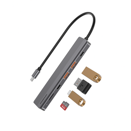 Gray USB hub with various attached devices on a white background